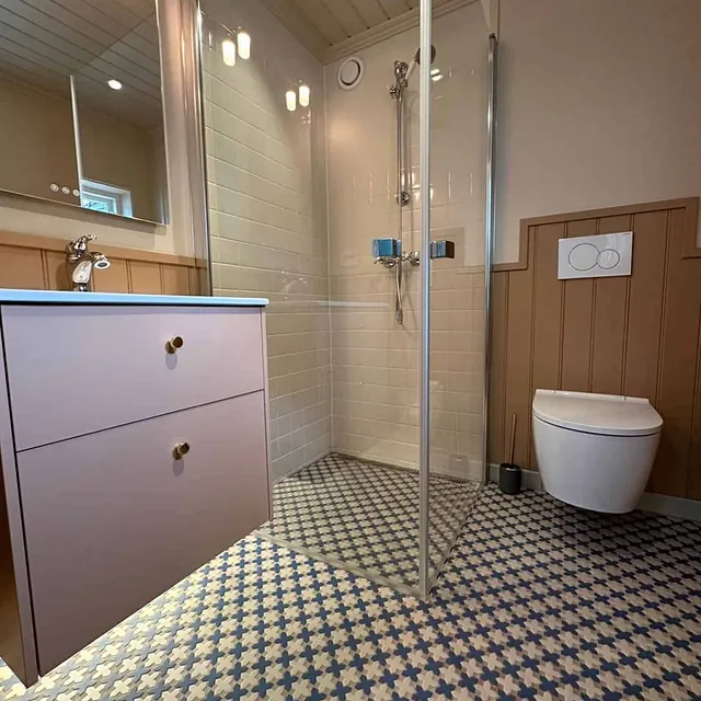 Et moderne bad med en vask, et toalett og en dusj.